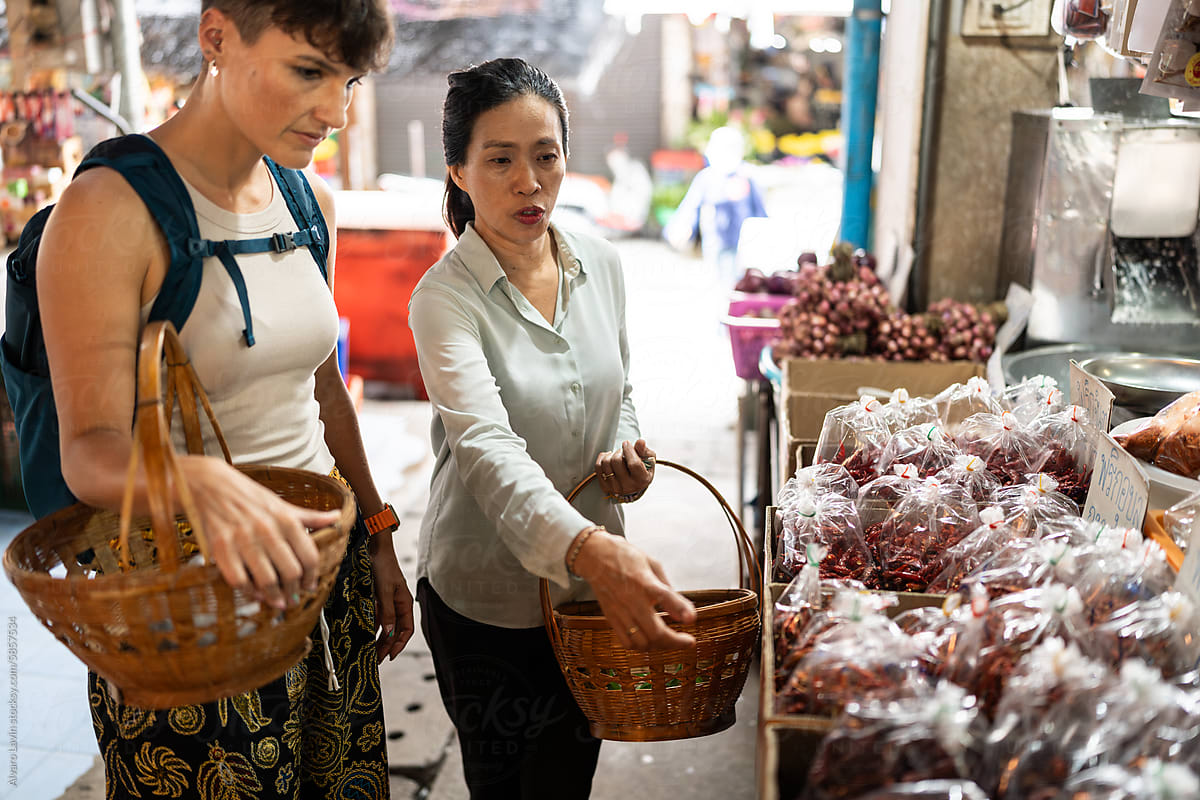Tourist woman with guide in a market.