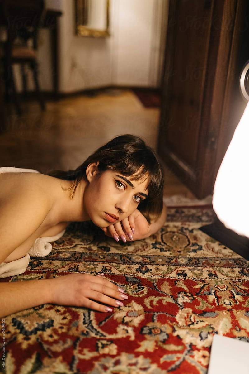 Young woman lying on carpet in room