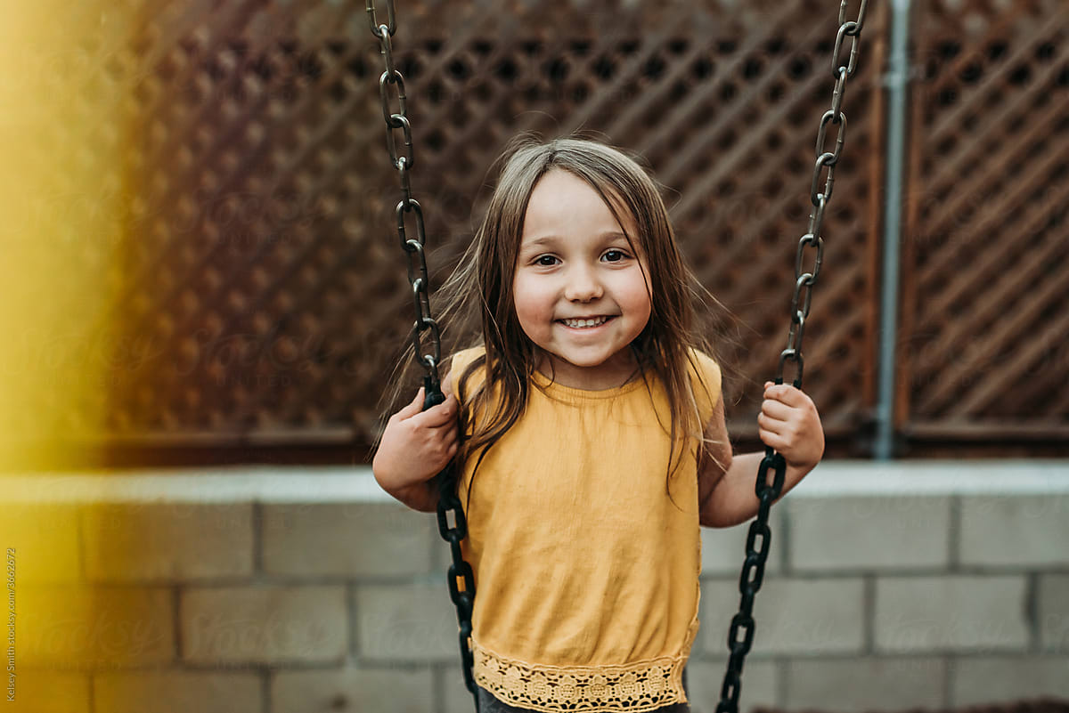 Smiling girl on swings