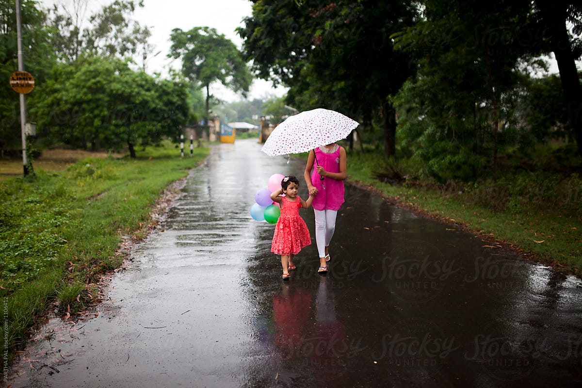 Sisters walking on wet road in rainy season together