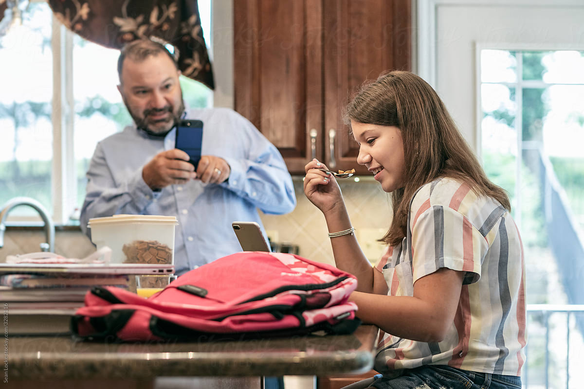 Morning: Girl Eats While Dad Takes First Day Of School Photo