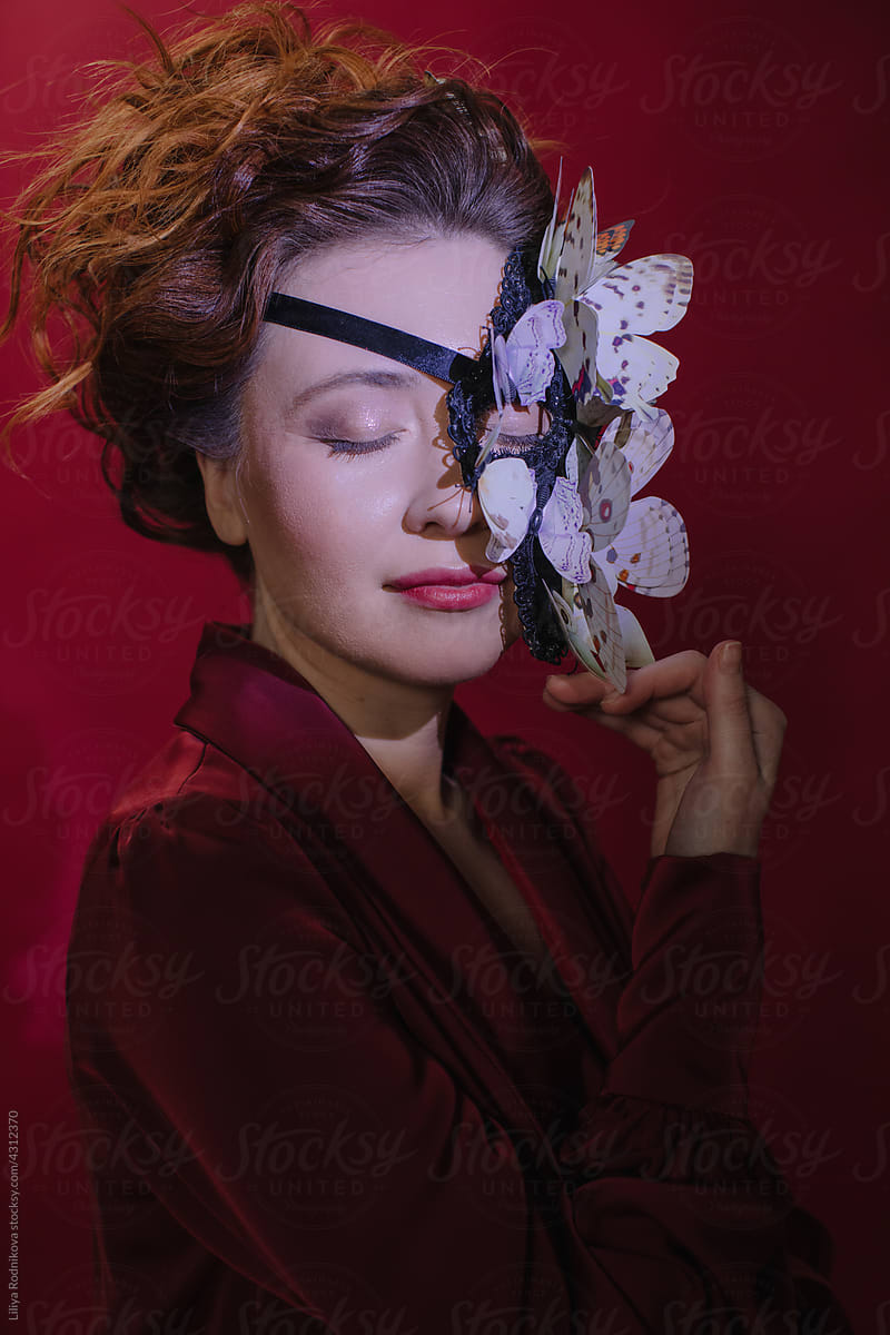 Dreamy portrait of red head woman in butterflies mask