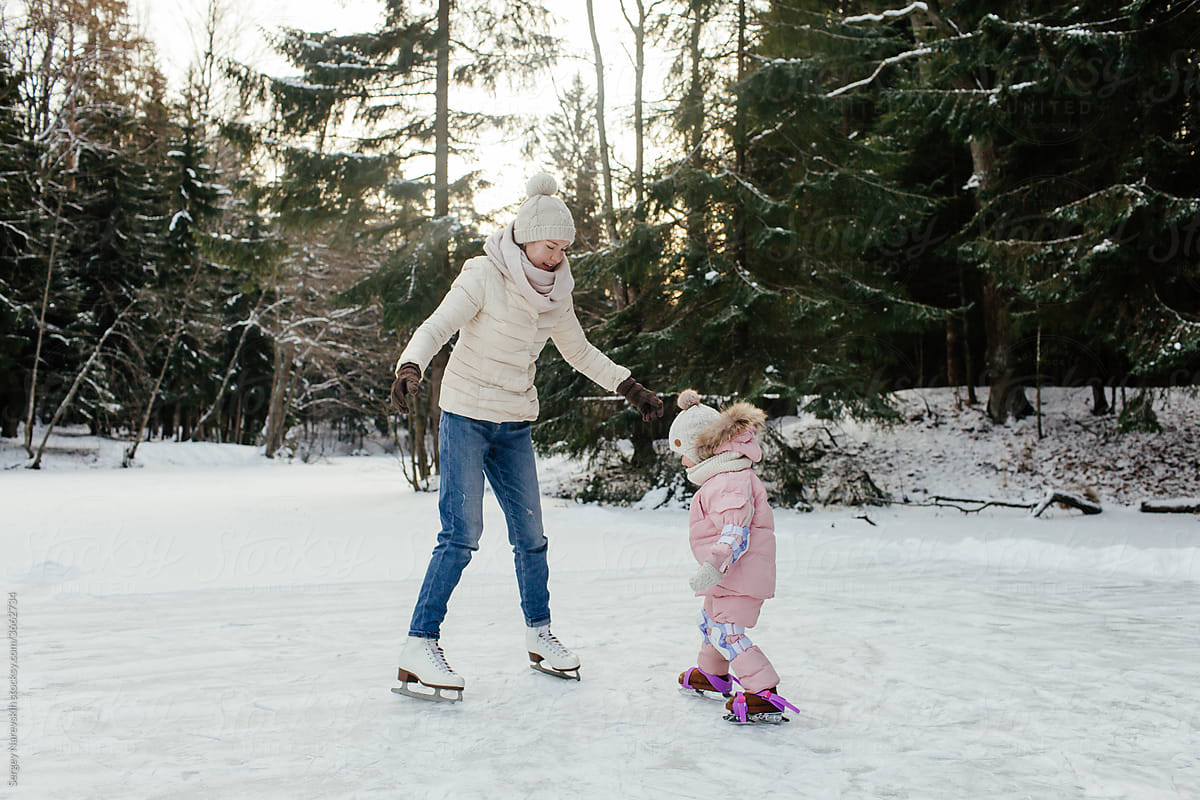 Happy little child with mom enjoying skating