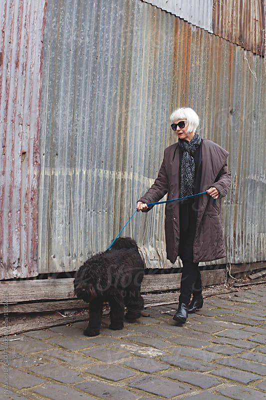 Older women walking dog in laneway of Melbourne, Australia