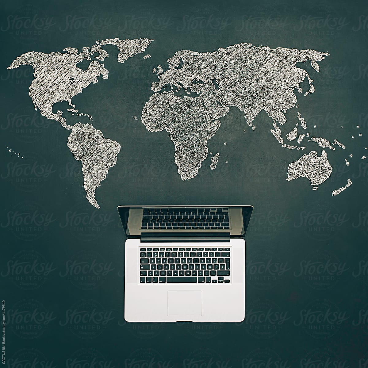 World map on chalkboard with a notebook computer