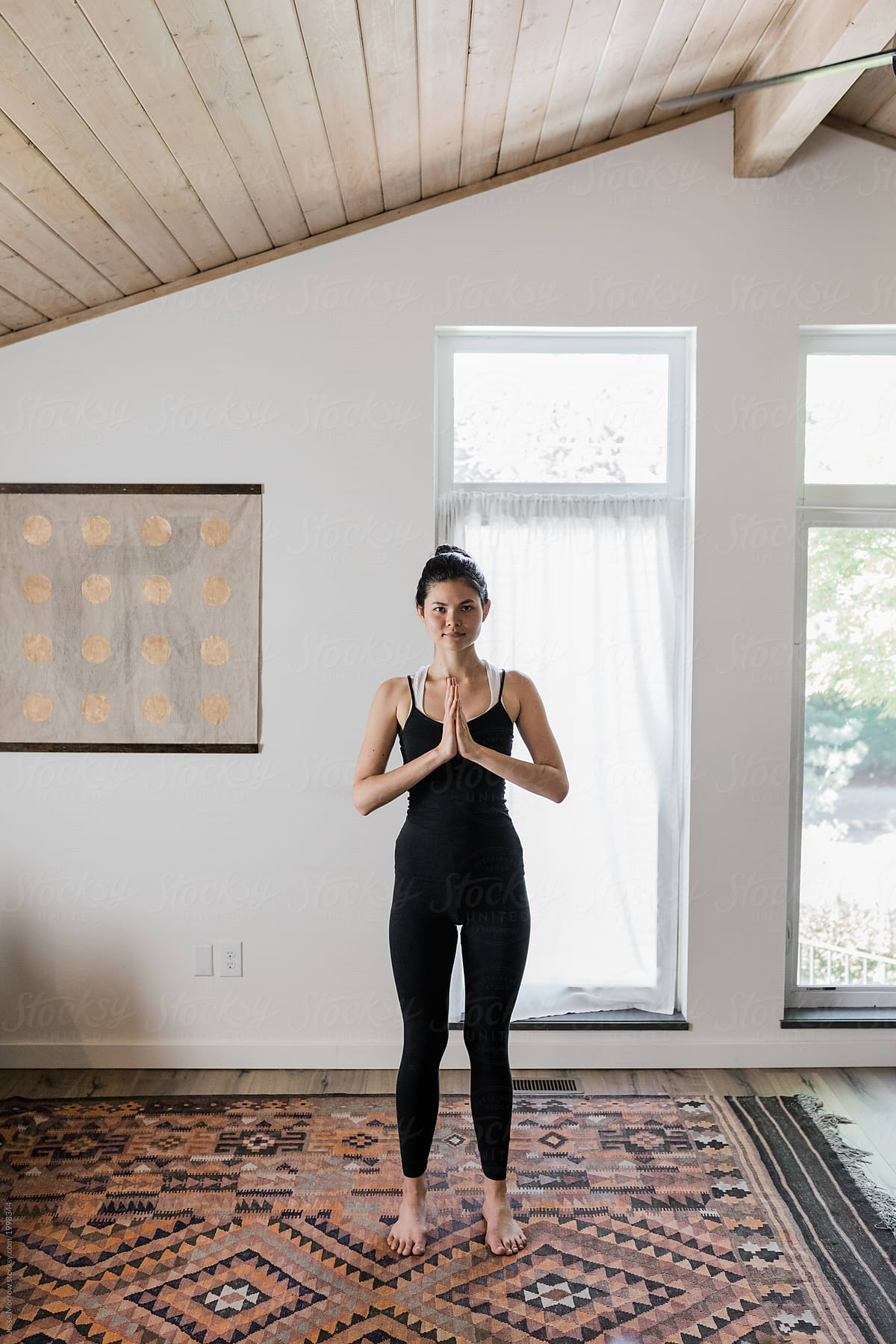young woman practices yoga in modern house