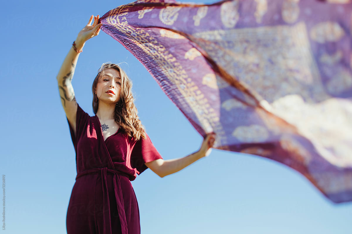 Model posing with scarf against the sky