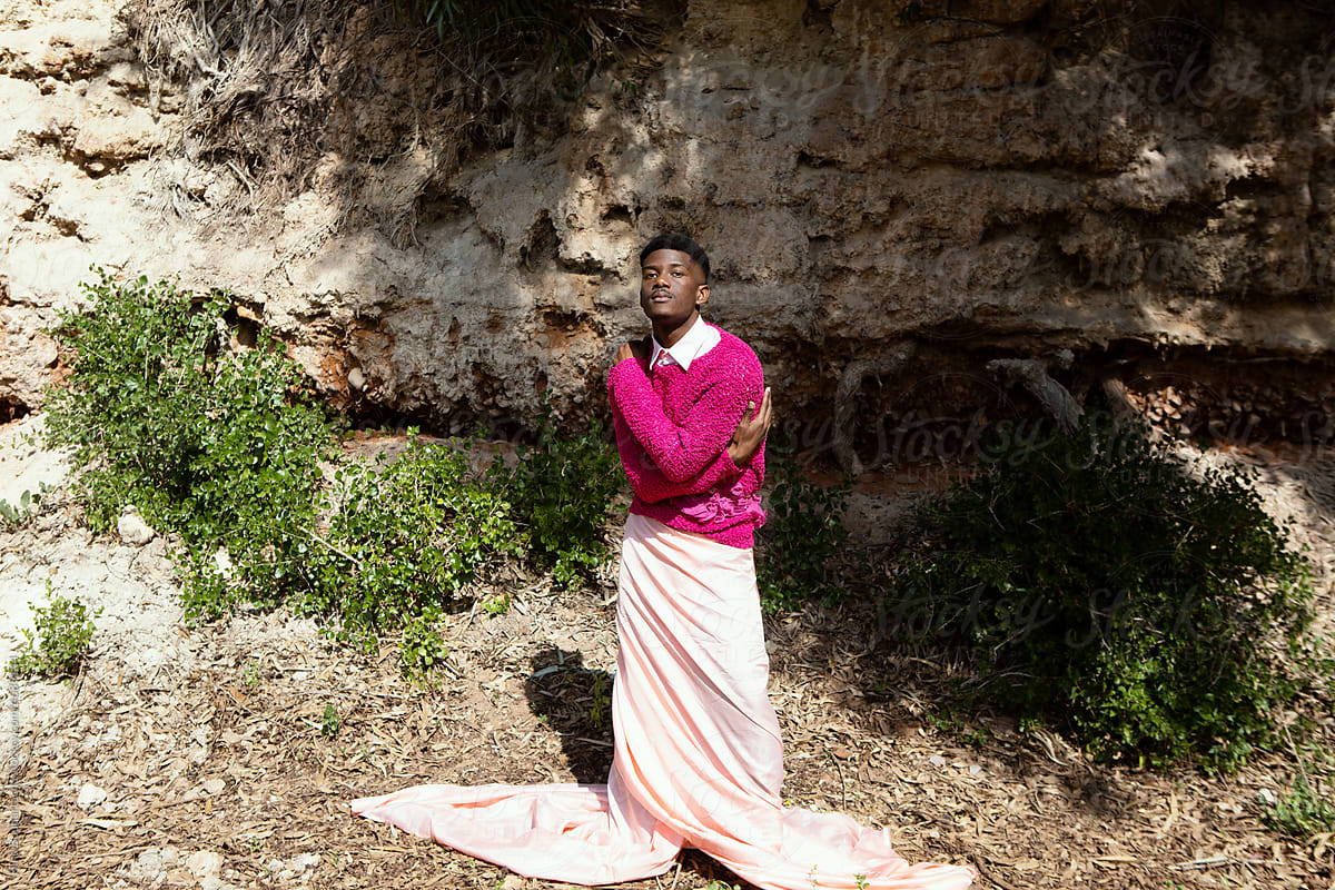 Young confident black man posing in nature on a sunny day wearing pink