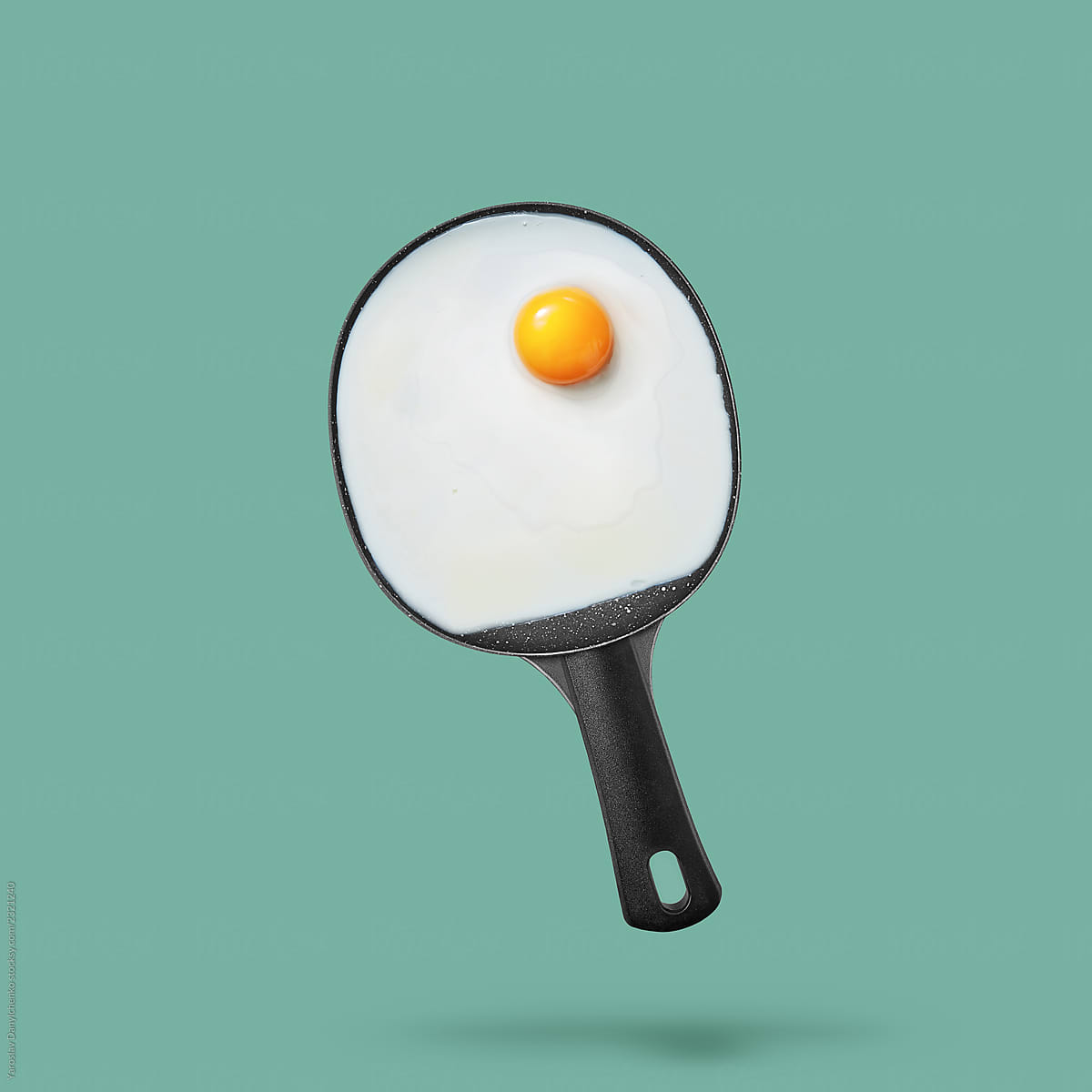 Fried eggs in a pan shaped racket on a green background with spa