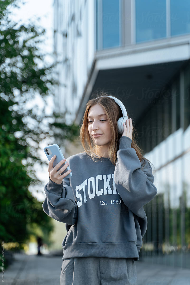 Young student girl with smartphone and headphones