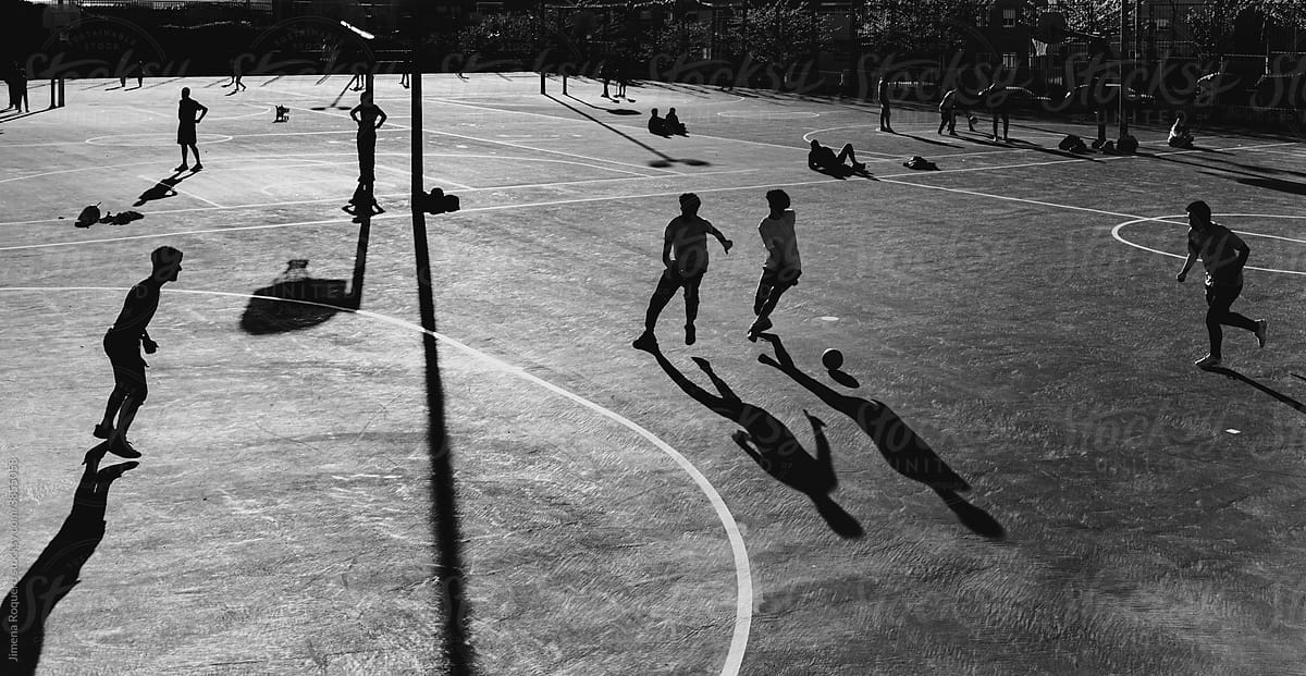 Urban scene of anonymous soccer players in an outdoor concrete field
