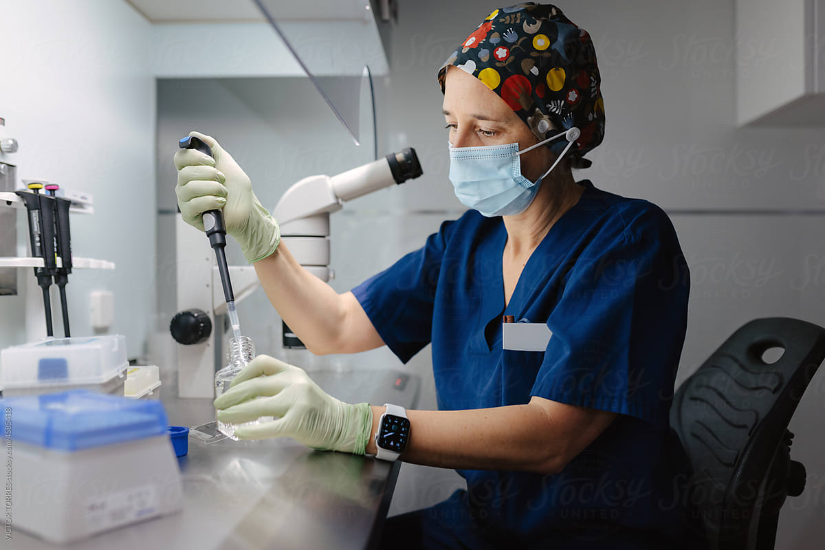 Biologist in mask preparing tests in laboratory