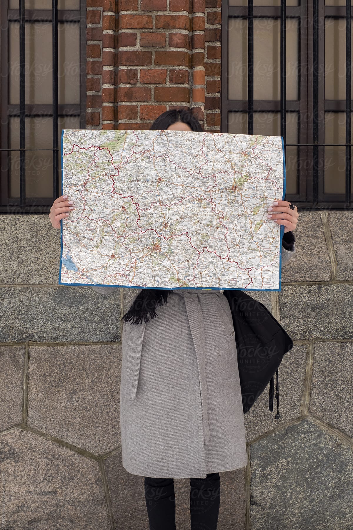 Woman covered face with map