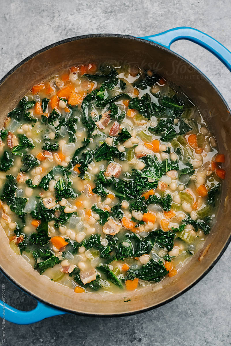 White bean soup with curly kale in a Dutch oven