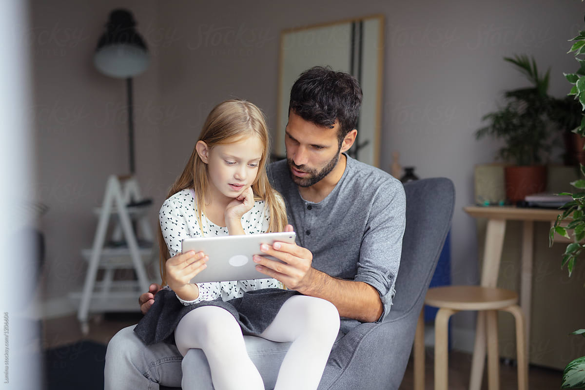 Father and Daughter Reading from Tablet Together