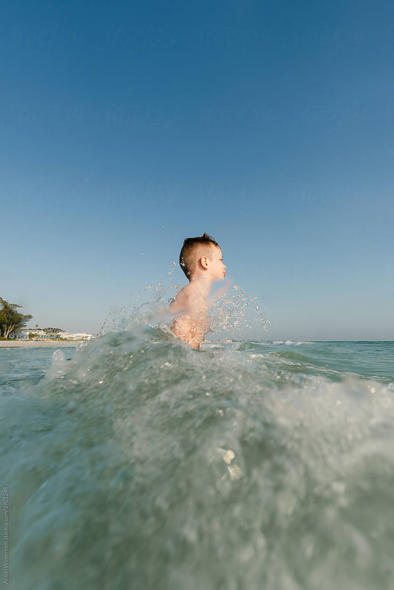 Boy getting splashed with a wave