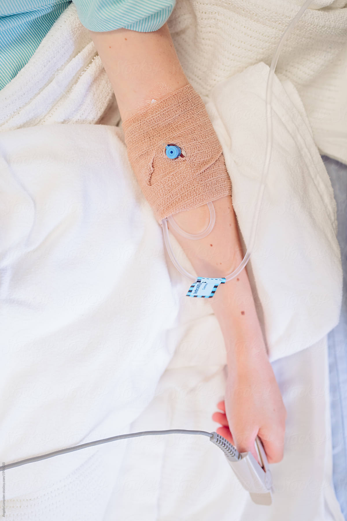 Child in a hospital bed with an intravenous cannula in his arm