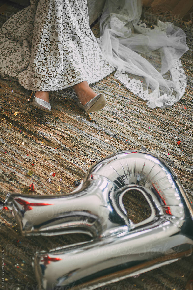 Bride legs with `R` balloon on the ground.
