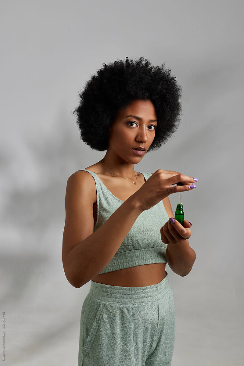 Black woman applying cosmetic serum