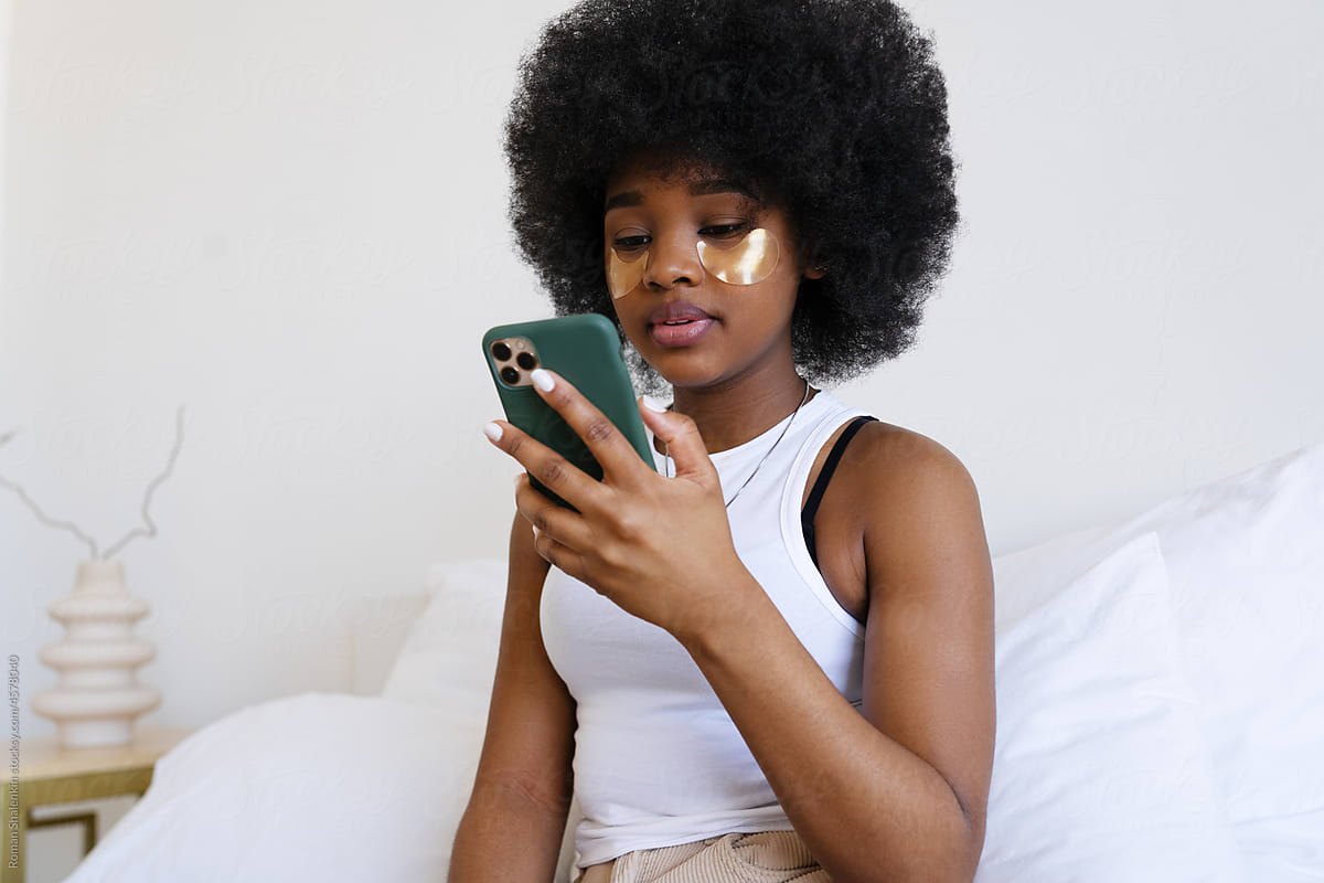Beautiful African American Girl Using Her Mobile Phone at Home