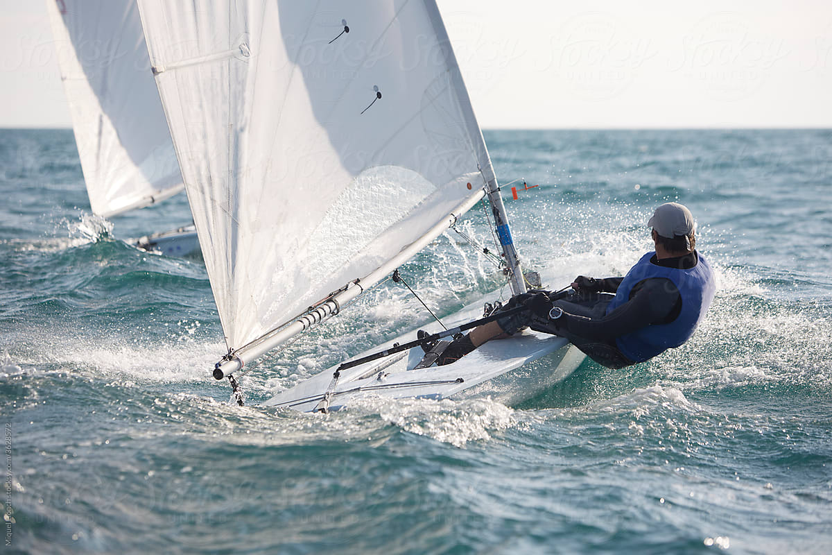 Action shot of sport sailor on a small sailboat \
 in the ocean.