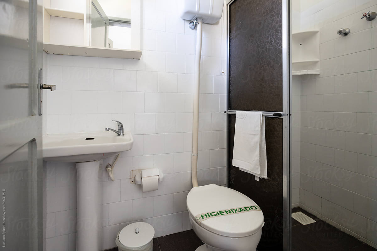 Clean and bright hotel room bathroom with shower, toilet and washbasin