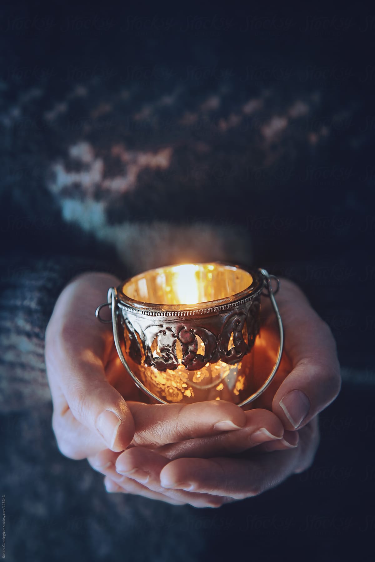 Woman holding a votive candle in her hands