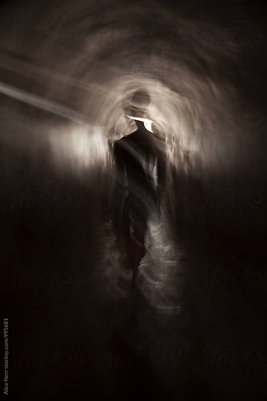 Woman\'s silhouette walking away in a tunnel