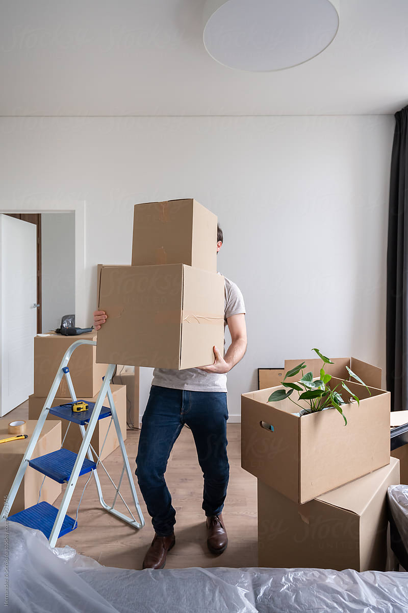 Man Holding Heavy Boxes Indoors