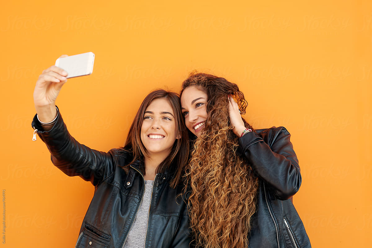 two Attractive girlfriends taking selfie