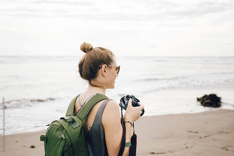 Female traveller with her camera on the beach