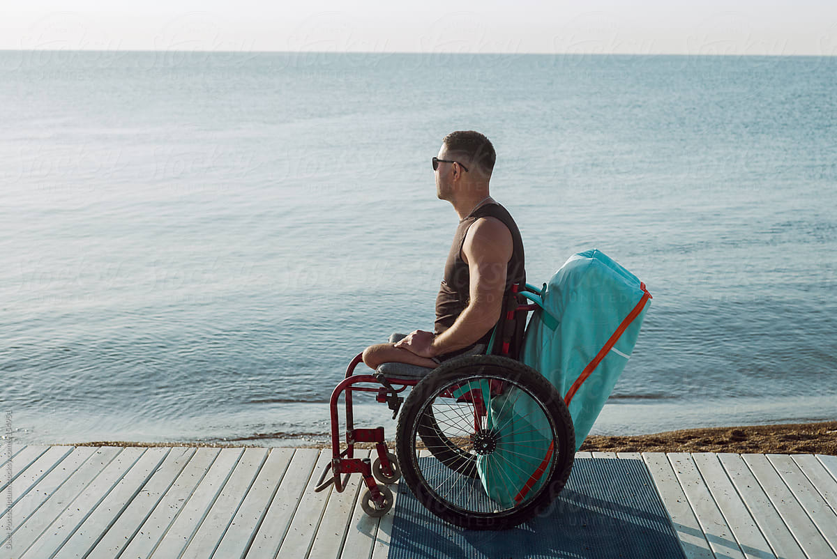 A man in a wheelchair enjoys the view of the sea