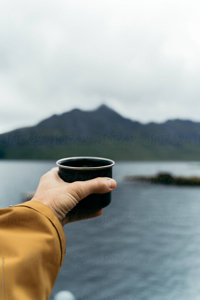 Man hold coffee cup in nature