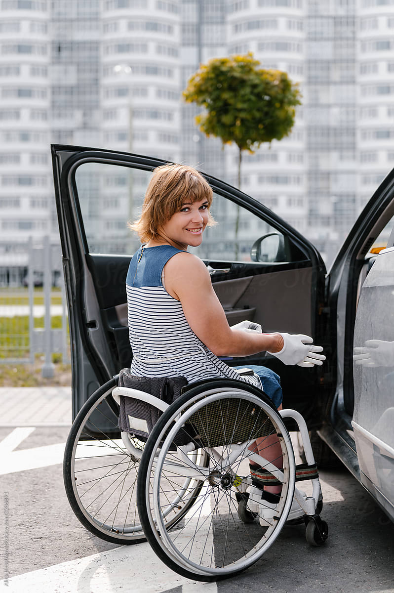 Woman on wheelchair near car