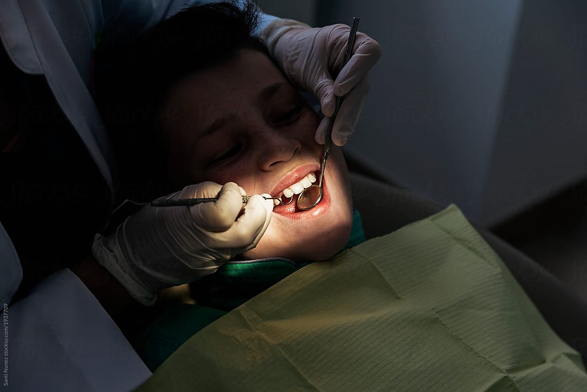 Close up of dentist during a dental intervention with a patient.