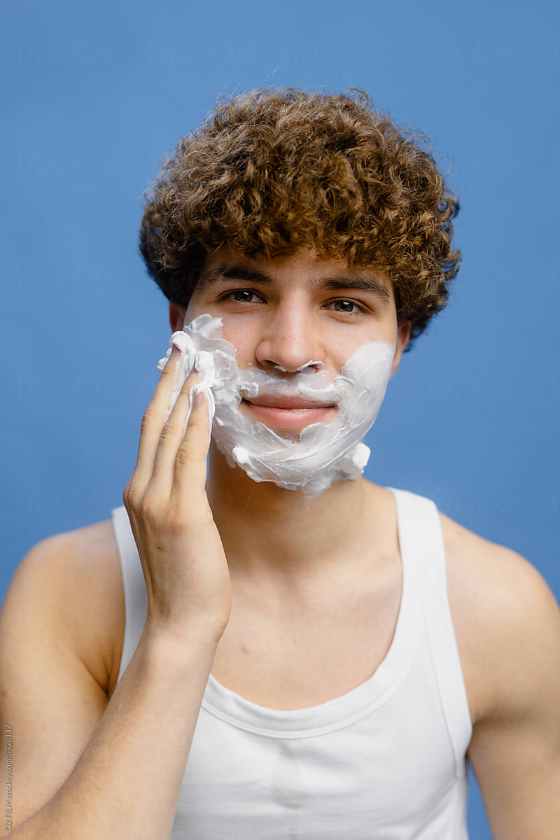 A man puts shaving foam on his face