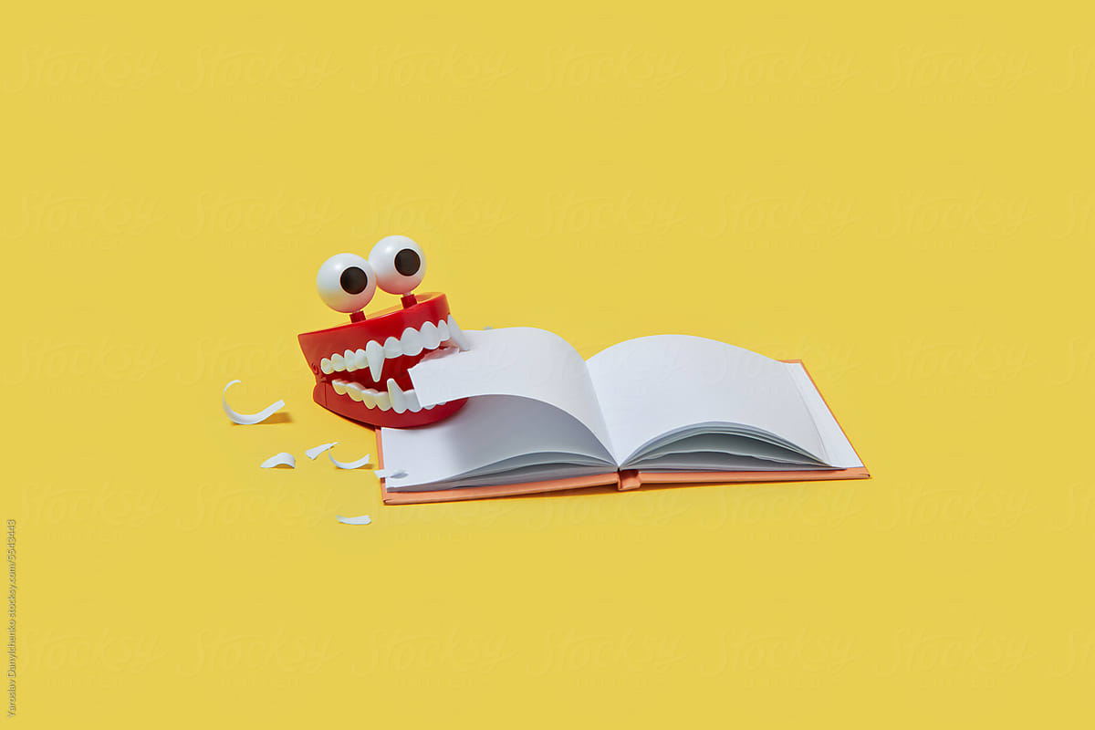 Red plastic jaws eating blank book.