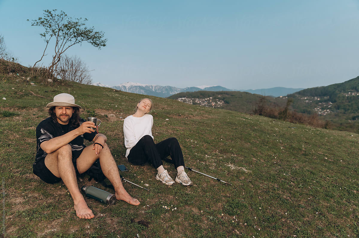 Couple resting on hill in evening