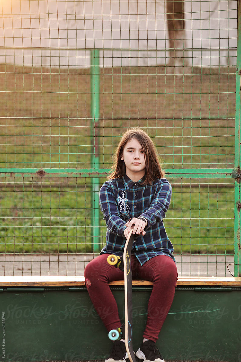 The girl with a skateboard on the playground