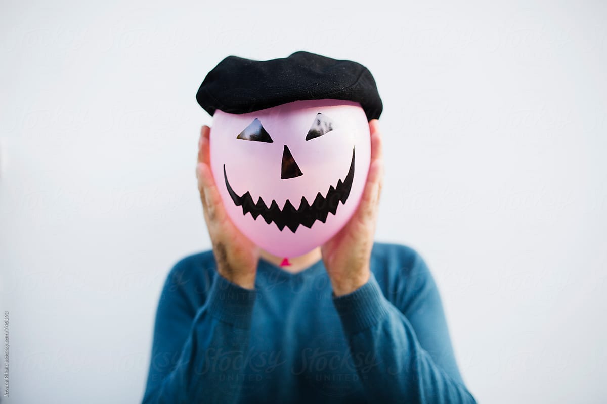 Man  holding halloween balloon in front of his face