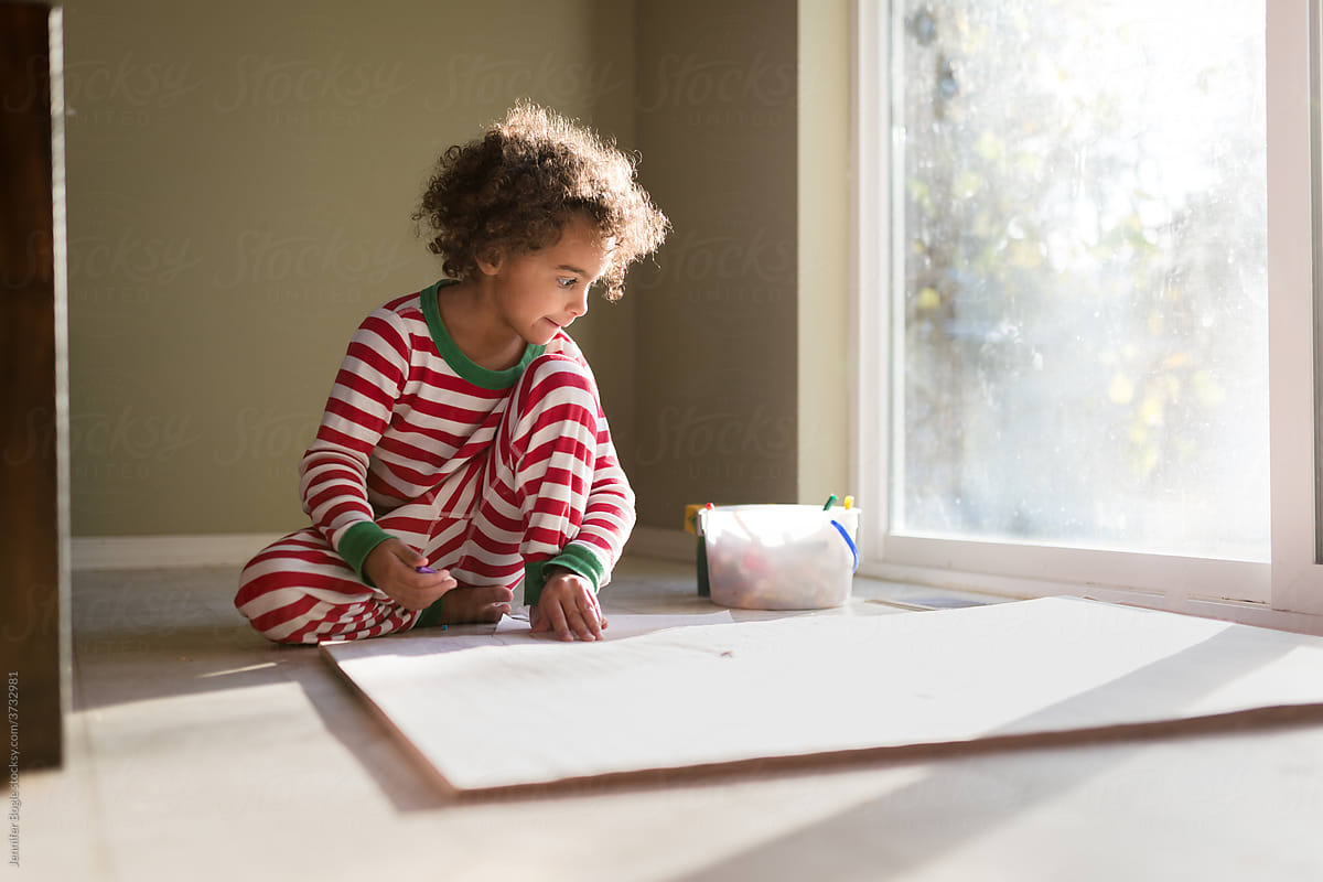 curly haired girl drawing on huge paper