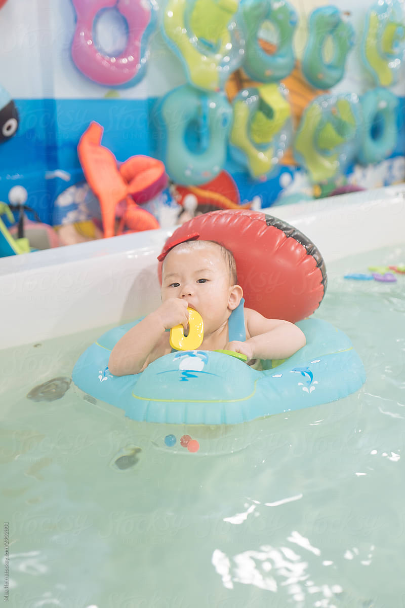 A baby girl swimming in a swimming ring