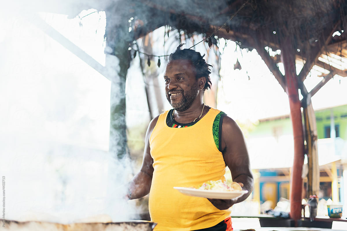 Afro-Caribbean man cooking on a barbeque