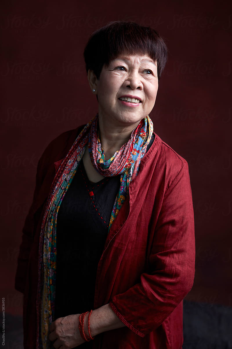 Portrait of middle-aged Asian woman, wearing traditional Chinese dress, indoors.
