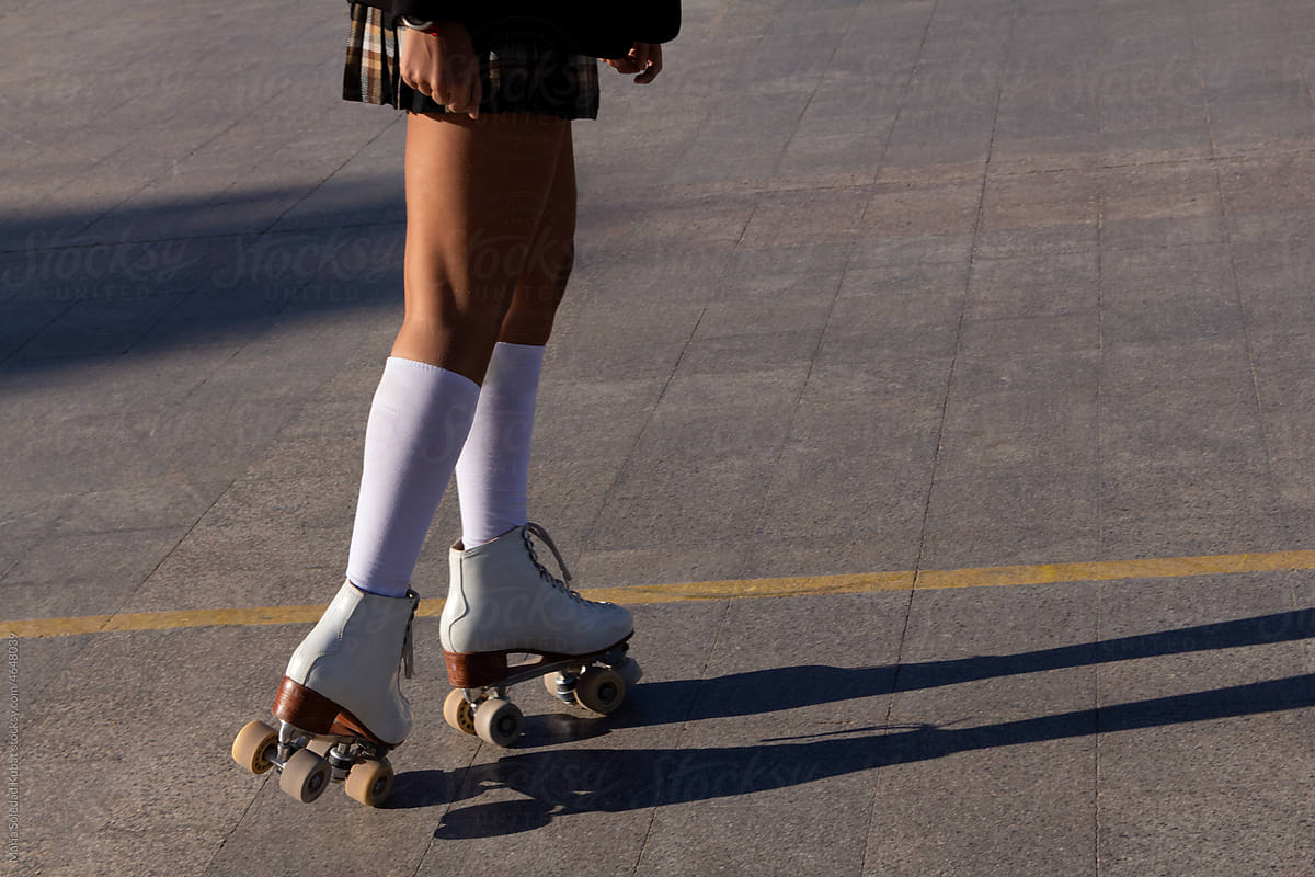 Anonymous woman\'s legs skating on a court