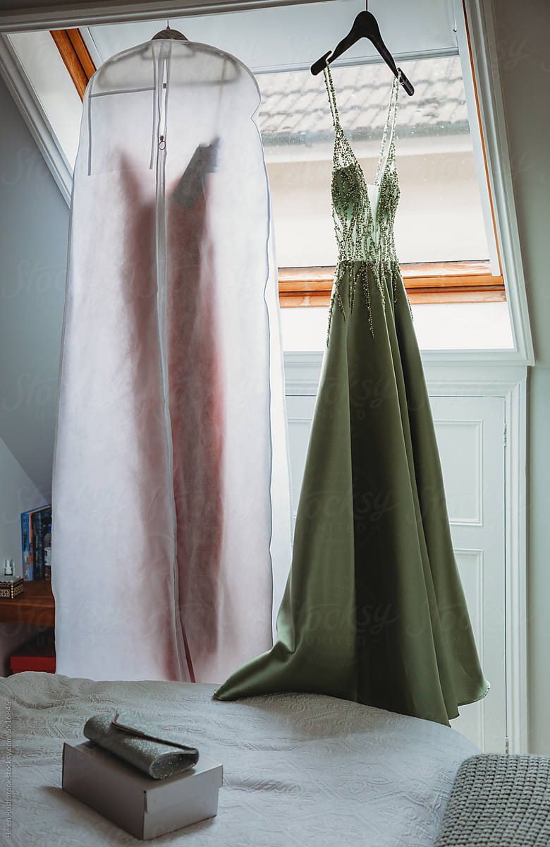 Evening dresses hanging up in a bedroom.