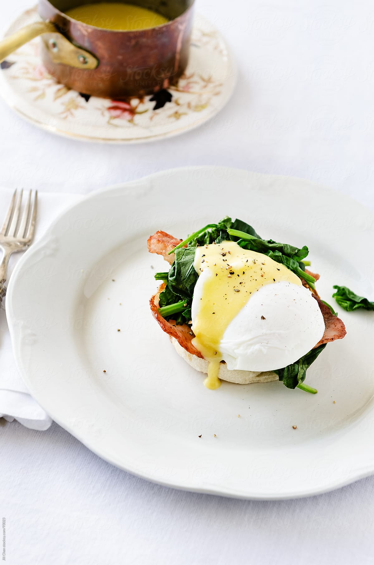 Eggs benedict florentine with hollandaise sauce, spinach and bacon