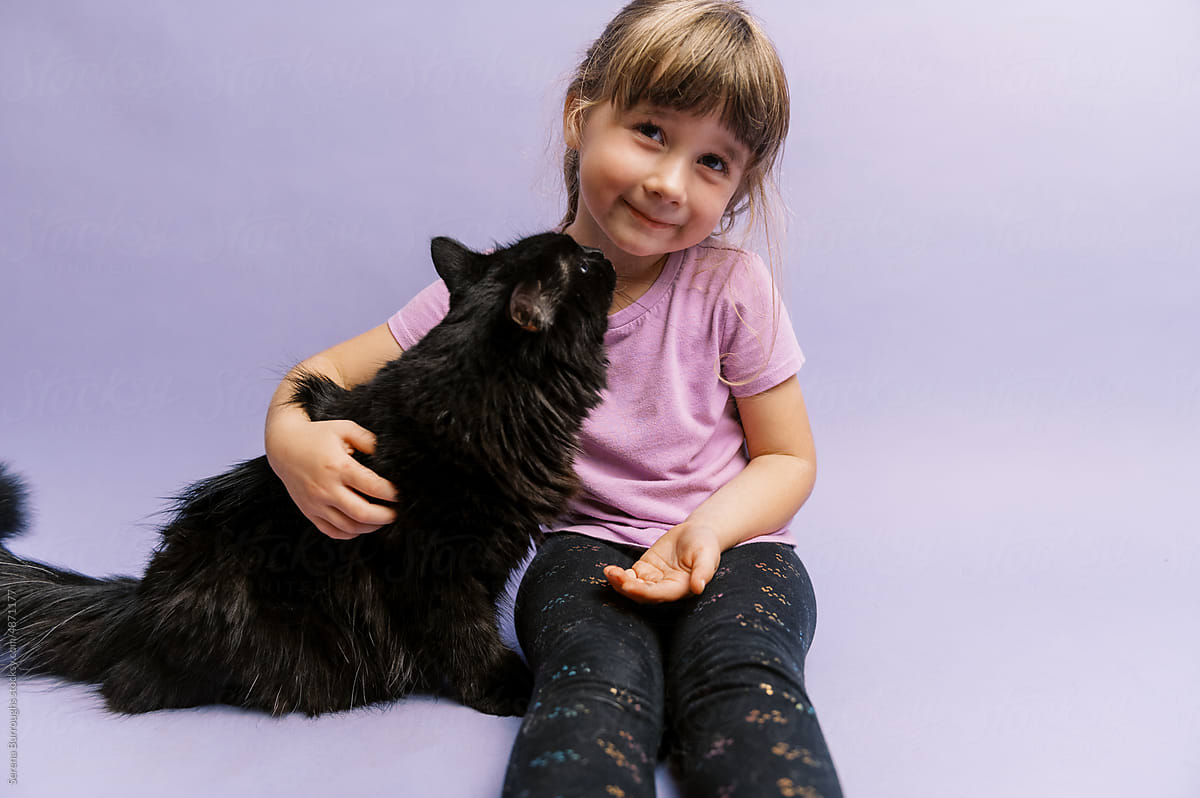 Little girl in purple with her black cat