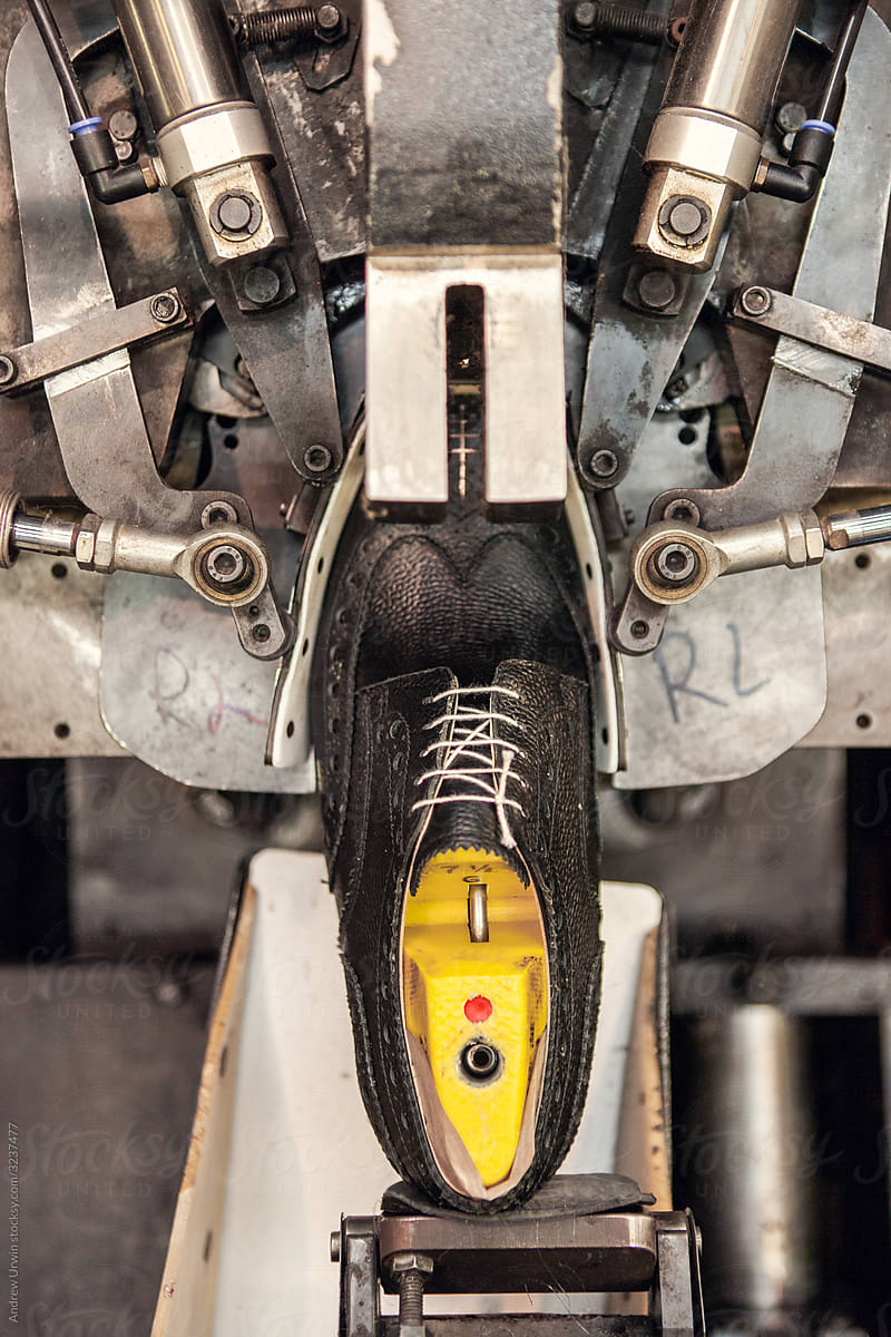 A shoe being held in a machine in a shoe factory