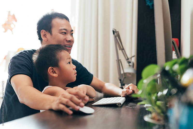 Father and son using computer at home